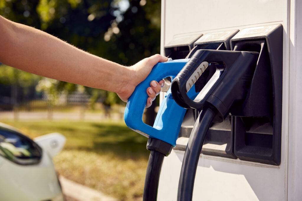 close up de mano usando una estación de carga de gasolina